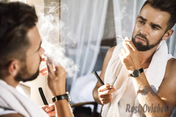 man looking in the mirror smoking a cigarette and shaving his beard with a straight razor - straight razor blades s and pictures best straight razor blades