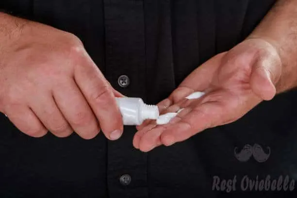 closeup of male hand pumping out cream from white bottle on forefinger. - hand lotion men s and pictures A Few Important